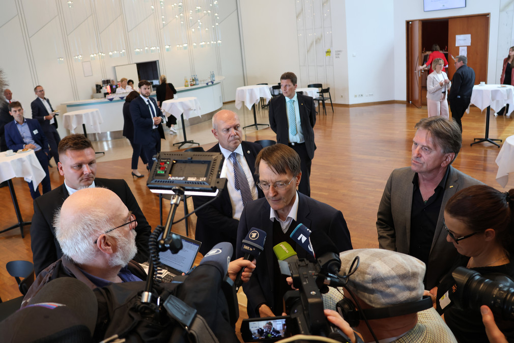 Bundesgesundheitsminister Karl Lauterbach und Baden-Württembergs Gesundheitsminister Manne Lucha sprechen mit der Presse, mehrere Kamerateams im Hintergrund.